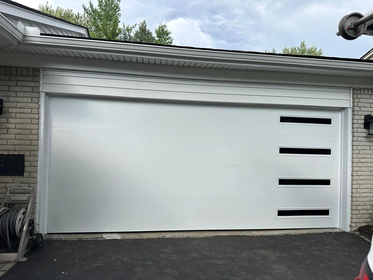 White sectional garage door with four narrow windows on the right