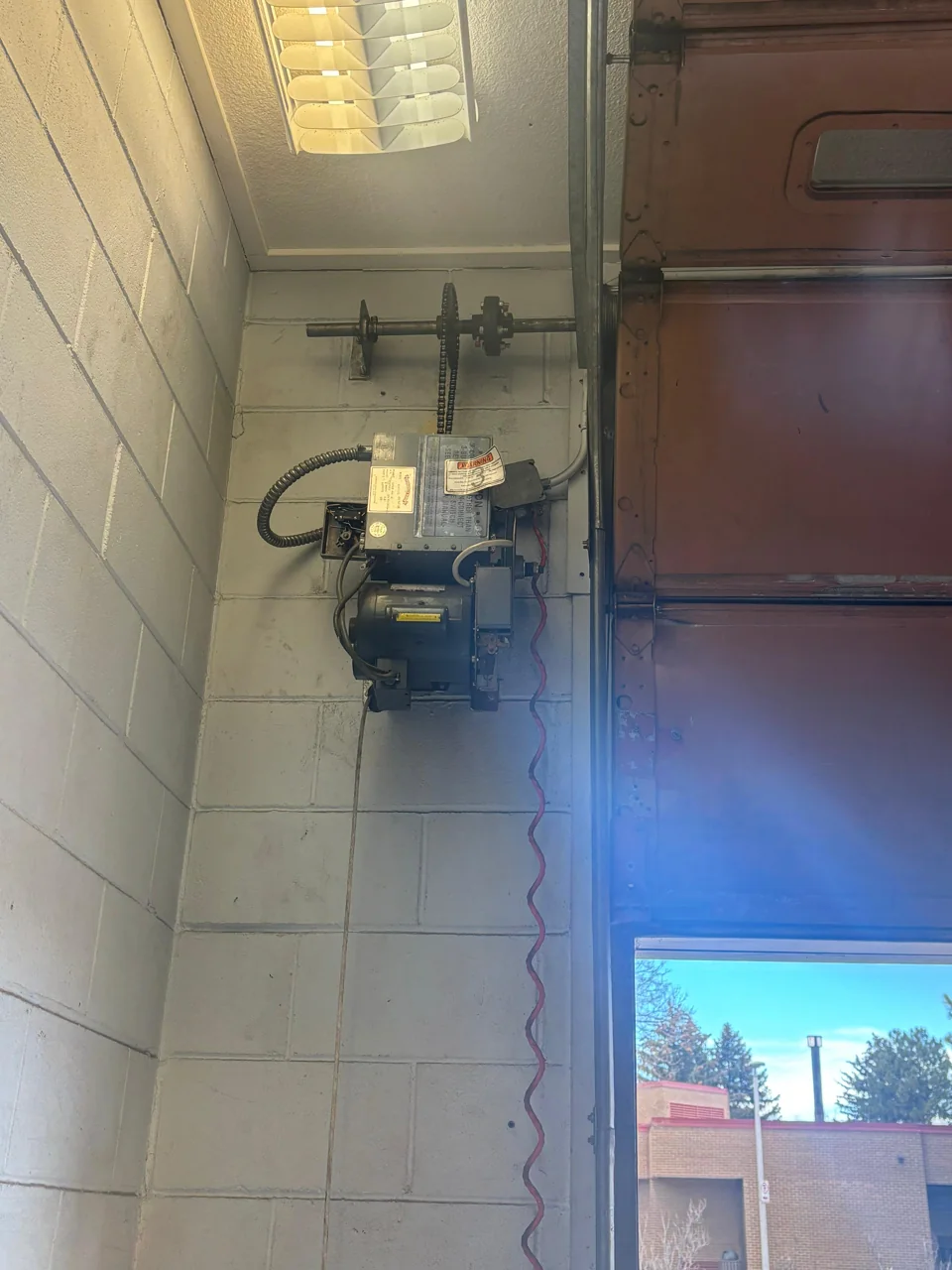 Wall-mounted opener beside a sectional door