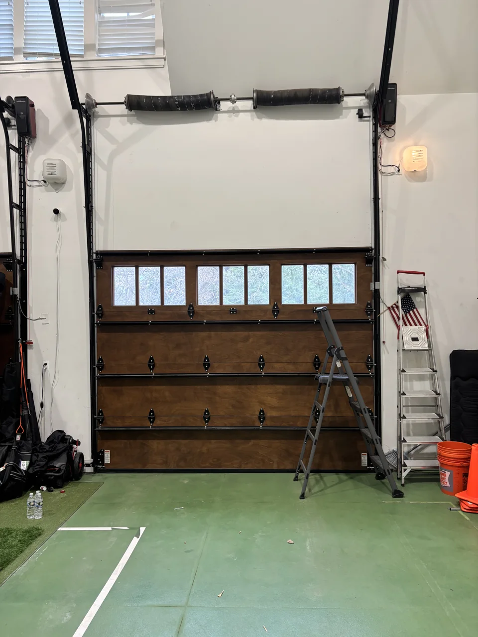 Wood-finish garage door and spring system seen from inside