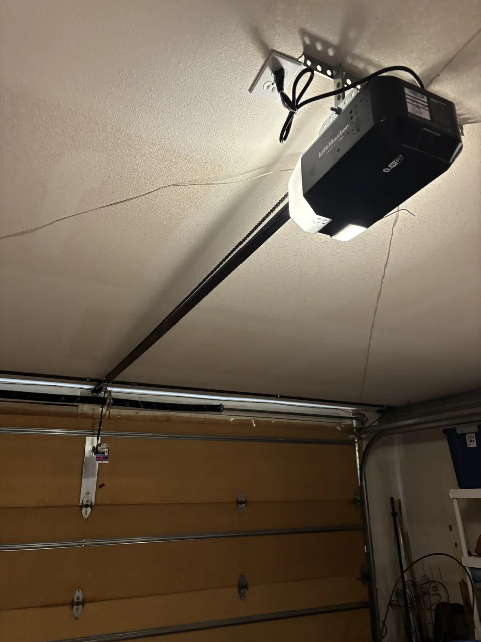Garage door opener mounted above a wood-finish sectional door