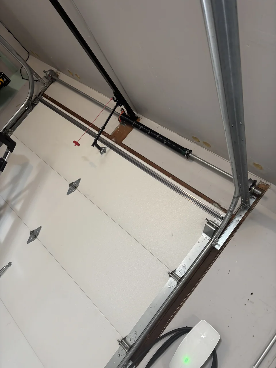 Garage door spring shaft, end bracket and track viewed from inside