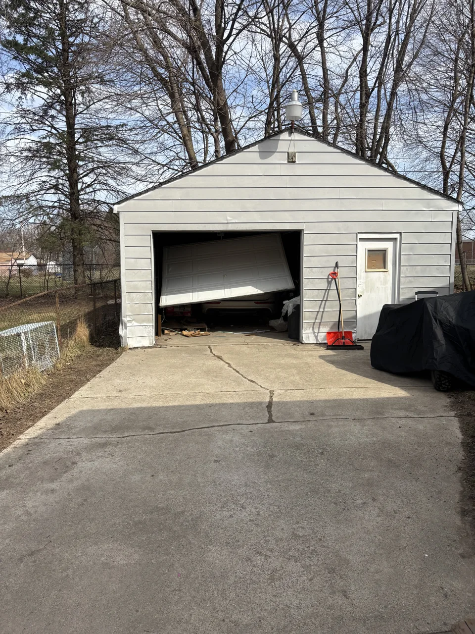 Detached garage with a visibly crooked door in the opening